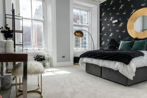 a bedroom with a bed and a wall with birds on it at Beautiful 4 bed flat in perfect central location in Glasgow