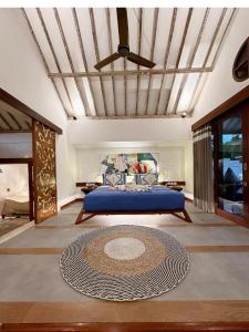 a bedroom with a blue bed and a ceiling at The White Key Luxury Villas in Gili Trawangan
