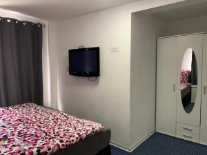 - une chambre avec un lit et une télévision murale dans l'établissement Haus Michel, à Bad Wildungen