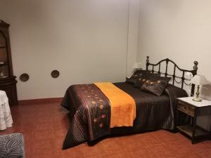 a bedroom with a bed with an orange and black blanket at MRZ rentals LA CASINA in Cudillero