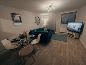 a living room with a couch and a table and a tv at 2br Cosy City Centre Apartment in Belfast
