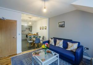 sala de estar con sofá azul y mesa en Fflat Cynan @ Nos Da, en Menai Bridge