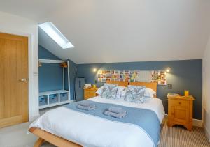 a bedroom with a large bed with blue walls at Fflat Cynan @ Nos Da in Menai Bridge