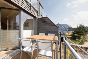 a balcony with a wooden table and chairs at Suite Strandrose in Zingst