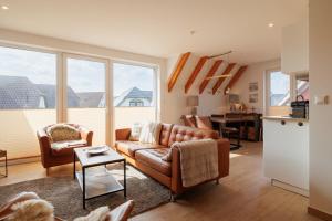 a living room with a couch and two chairs at Suite Strandrose in Zingst
