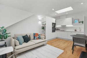 uma sala de estar branca com um sofá e uma cozinha em Home Away from Home Stylish Apartment Retreat em Eastbourne