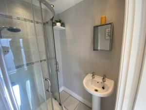 a bathroom with a sink and a glass shower at 2br Cozy Duplex in Belfast