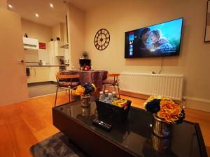 ein Wohnzimmer mit einem Flachbildfernseher an der Wand in der Unterkunft 2br Modern Luxury Loft Apartment in Belfast