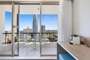 a room with a balcony with a view of a city at Ocean View Surfers Paradise Studio Close to Beach in Gold Coast