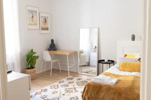 a bedroom with a bed and a desk and a mirror at 2ndhomes Fabianinkatu Apartments in Helsinki