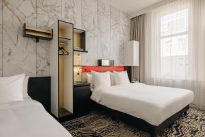 een hotelkamer met 2 bedden en een raam bij The Lancaster Hotel Amsterdam in Amsterdam