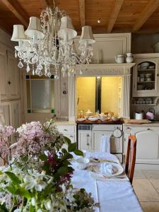 Nueil-sur-LayonにあるChambre de charme dans un jardin de 1500m2のキッチン(ダイニングテーブル、シャンデリア付)
