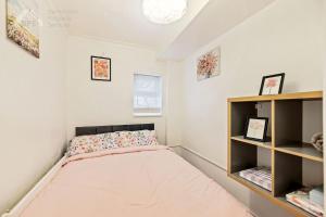 a small bedroom with a bed and shelves at Cosy Tottenham Apartment sleeps 4 in London