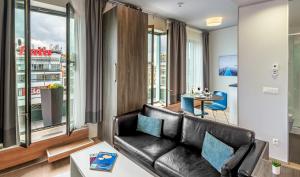 sala de estar con sofá de cuero y mesa en VN3 Terraces Suites by Adrez, en Praga