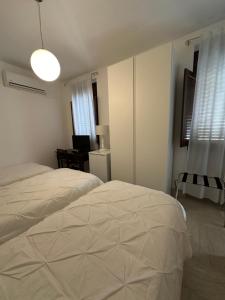 a bedroom with two beds and a desk in it at Crispi 10 in Floridia