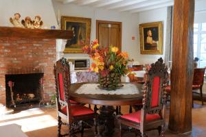 uma sala de jantar com uma mesa e uma lareira em B&B Domein Rodin em Oud-Turnhout