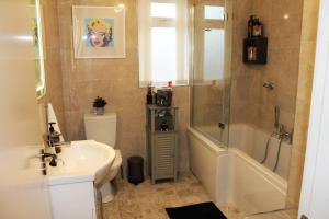 a bathroom with a sink and a tub and a toilet at 4 Bed Boutique House Lisburn Road in Belfast