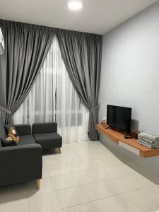 a living room with a couch and a television at Ipoh Town Anderson Hana Suite 7 paxs 2R2B in Ipoh