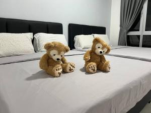 two teddy bears sitting on top of a bed at Ipoh Town Anderson Hana Suite 7 paxs 2R2B in Ipoh