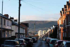 una strada cittadina con auto parcheggiate sul lato della strada di 4 Bed Boutique House Lisburn Road a Belfast