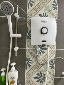 a bathroom with a shower with a hair dryer and a soap dispenser at Ipoh Town Anderson Hana Suite 7 paxs 2R2B in Ipoh