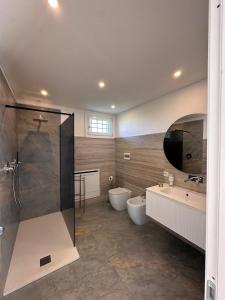 a bathroom with two sinks and a shower and two toilets at Villa Iris in Modena