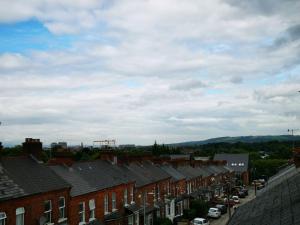 a row of brick houses in a town with cars at 4br Modern Botanic House in Belfast