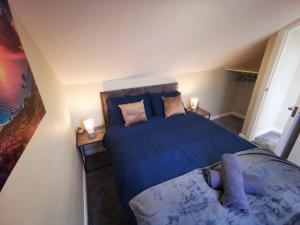 a bedroom with a blue bed and a couch at 4br Modern Botanic House in Belfast