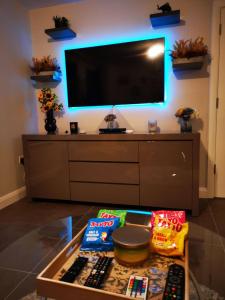 ein Wohnzimmer mit einem TV und einem Tisch mit Snacks in der Unterkunft Belfast Central 2 Bedroom Luxurious Modern Stay in Belfast