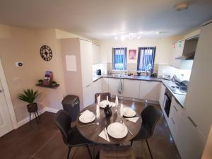 a kitchen with a table and chairs in a room at Belfast Central 2 Bedroom Luxurious Modern Stay in Belfast