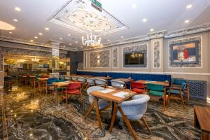 イスタンブールにあるBest Nobel HotelS 2 Aksaray İstanbul -Specialのテーブルと椅子、シャンデリアのあるレストラン