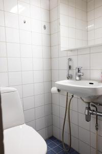 a white bathroom with a sink and a toilet at 2ndhomes Fabianinkatu Apartments in Helsinki