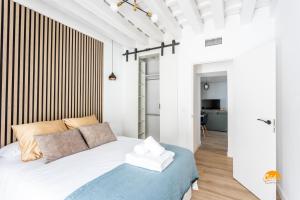 a bedroom with a bed with a blue blanket at Buenos Aires by Cadiz Time in Cádiz