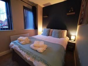 a bedroom with two towels on a bed at Belfast Central 2 Bedroom Luxurious Modern Stay in Belfast