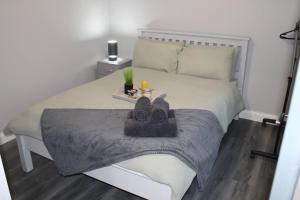 ein Schlafzimmer mit einem Bett mit einem Tablett mit Schuhen darauf in der Unterkunft Forest View Cottage - Private Hot Tub in Ballynameen