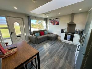 un soggiorno con un divano e un tavolo di Forest View Cottage - Private Hot Tub a Ballynameen