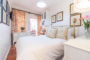 a white bedroom with a bed and a window at Kings and Kent in Cape Town