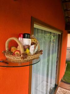 a basket of fruit on a glass shelf on a wall at Pousada Irmãos Tonoli in Venda Nova do Imigrante