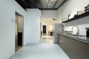 a kitchen with white walls and a white floor at Mono Ipoh - Bercham, 2 parking, sleep 10, Lost World Tambun in Ipoh