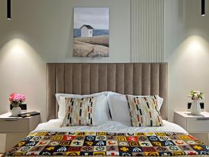 Очаровательные апартаменты в ЖК Комфорт Сити في ألماتي: غرفة نوم بسرير كبير مع اللوح الأمامي