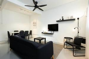 a living room with a couch and chairs and a tv at Mono Ipoh - Bercham, 2 parking, sleep 10, Lost World Tambun in Ipoh