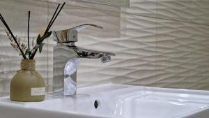 a bathroom sink with a faucet and a vase of flowers at Cliff Refuge by LovelyStay in Santa Cruz +15 photos