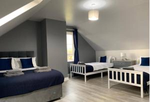 a bedroom with two beds with blue and white at Forest View House & Hot Tub Sleeps 9 in Ballynameen