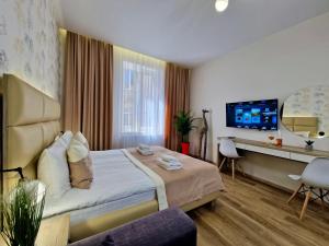 ein Hotelzimmer mit einem Bett und einem TV in der Unterkunft DeMar Apart Vicheva in Lwiw