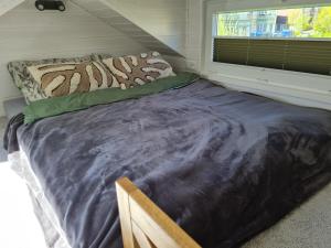 a large bed in a small room with a window at Red Tiny House in Sopot