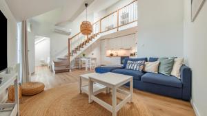 un soggiorno con un divano blu e un tavolo di Prywatne apartamenty w obiekcie Nautikka Resort, Sun & Snow a Krynica Morska