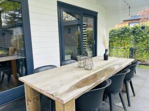 een houten tafel op een patio met stoelen bij BPW 1155 - Bospark Wolfsven in Mierlo