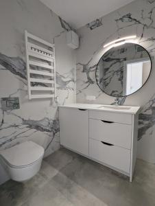 a bathroom with a toilet and a mirror at Apartament nad Morzem w Sea & Lake Mielno in Mielno