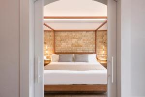 1 dormitorio con 1 cama a través de una puerta de cristal en Hotel Cala del Pi - Adults Only en Platja  d'Aro