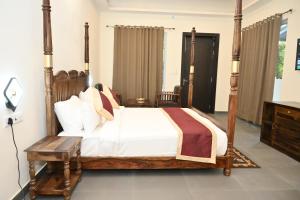 Ranthambore Tiger Inn Comfort Resort في ساواي مادهوبور: غرفة نوم بسرير كبير مع اطار خشبي